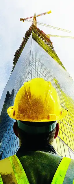 a construction worker and a skyscraper under construction