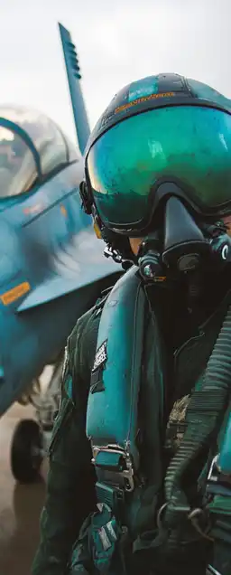 a fighter jet pilot with his helmet standing in front of his fighter jet