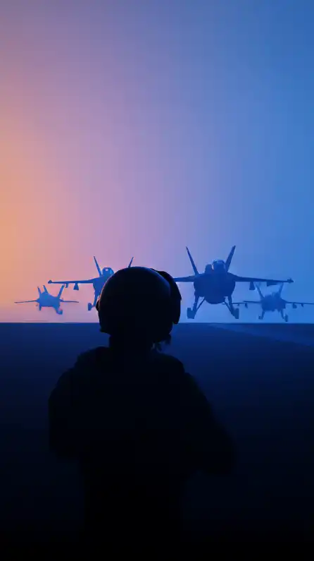a fighter jet pilot with his helmet standing on an aircraft carrier with fighter jets launching in the background