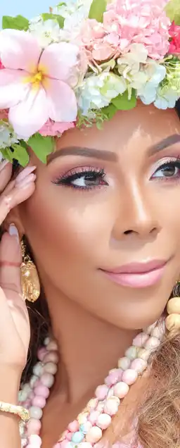 close up show of a hawaiian beaty with flowers in her hair and classic jewelry made out of wood and gold