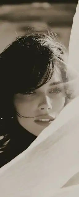 fashion shoot of a female top model with a transparent scarf in front of her face