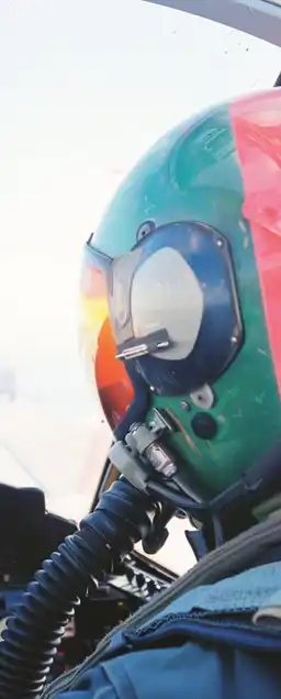 a fighter jet pilot wearing his helmet