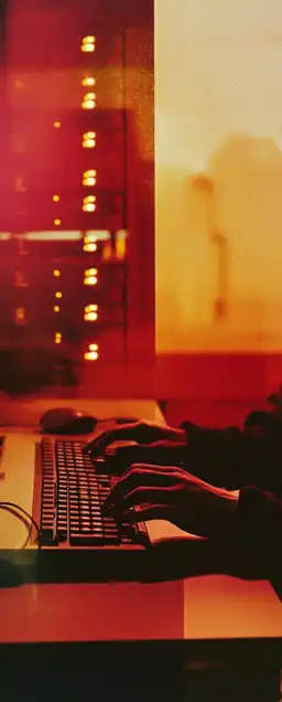 a server room and hands on a keyboard double exposure